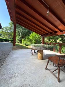 a picnic table and a bench under a pavilion at Finca La Sierra in Abionzo