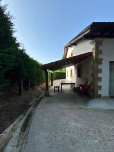 a patio of a house with a table and benches at Finca La Sierra in Abionzo