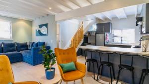 a kitchen and living room with a blue couch at The Fisherman's LAB Cabin in Hermanus