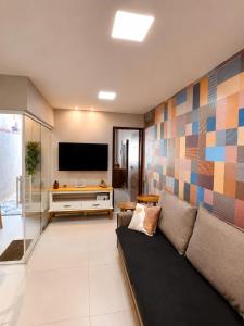 a living room with a couch and a flat screen tv at Recanto Serra e Mar in Angra dos Reis