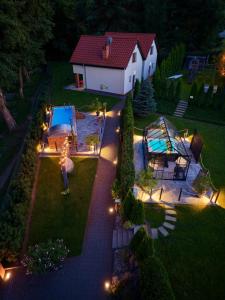 a backyard with a pool and a house with lights at Trzy Wyspy Barlinek in Barlinek