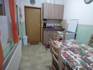 a kitchen with a table and a bed in a room at Kovács Vendégház in Zalaegerszeg