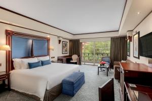 a bedroom with a large white bed and a desk at Kampala Serena Hotel in Kampala +66 photos