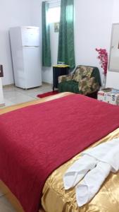 a bedroom with a large red bed with a chair at Suites in Domingos Martins