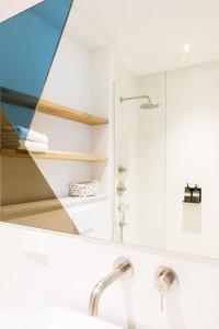 La salle de bains est pourvue d'un miroir au-dessus d'un lavabo. dans l'établissement Kith & Kin Boutique Apartments, à Amsterdam