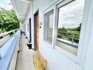 a balcony with a yellow bench and a window at J&D Fully-Aircon 400mbps Parking WiFi 6pax in Canaman
