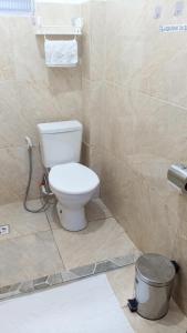 a bathroom with a toilet and a trash can at Suites in Domingos Martins +2 photos