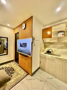 a kitchen with a tv on a wooden wall at J&D Fully-Aircon 400mbps Parking WiFi 6pax in Canaman