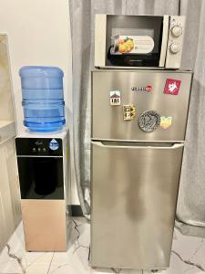 a small refrigerator with a microwave on top of it at J&D Fully-Aircon 400mbps Parking WiFi 6pax in Canaman