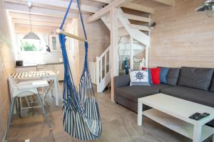 a living room with a couch and a hammock at Marynarskie Domki in Pobierowo