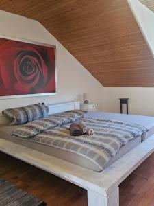 a large bed in a room with a wooden ceiling at Ferienwohnung Riesling in Burg