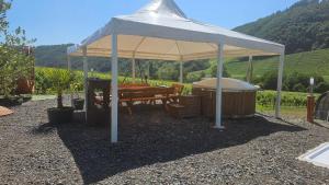 a white tent with a table and chairs under it at Camping Schlaffass Odin in Burg +5 photos