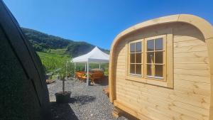 a small wooden shed with a table and an umbrella at Camping Schlaffass Odin in Burg