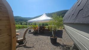 a tent with a table and a bench and plants at Camping Schlaffass Odin in Burg
