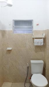 a bathroom with a white toilet and a radiator at Suites in Domingos Martins