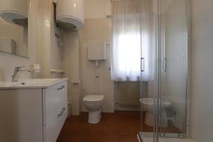 a bathroom with a toilet and a sink and a shower at Reunia apartments in Ragogna