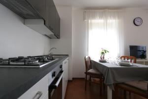 a kitchen with a stove and a table with chairs at Reunia apartments in Ragogna +6 photos