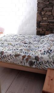 a bed with a comforter on top of it at Dix doré in Blaimont