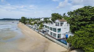 a row of houses on the shore of a beach at Absolute Oceanfront Tara Villa Beachfront 4 Bed in Ban Saiyuan (1)