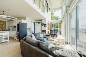 a living room with a large couch and a kitchen at Absolute Oceanfront Tara Villa Beachfront 4 Bed in Ban Saiyuan (1)