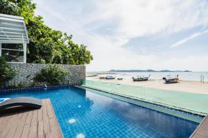 a swimming pool with a view of the beach at Absolute Oceanfront Tara Villa Beachfront 4 Bed in Ban Saiyuan (1)