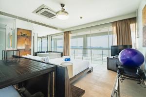 a bedroom with a bed and a desk and a television at Absolute Oceanfront Tara Villa Beachfront 4 Bed in Ban Saiyuan (1)