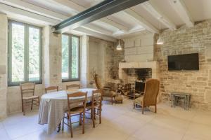 a dining room with a table and chairs and a fireplace at La Maison des mariés - Nature & Sèvre Niortaise in Sciecq