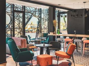 a room with chairs and tables and a large window at Novotel Paris Vaugirard Montparnasse in Paris