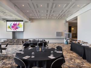 a room with tables and chairs and a projection screen at Mercure Queenstown Resort in Queenstown +146 photos