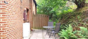 a patio with a table and chairs next to a brick building at Dix doré in Blaimont