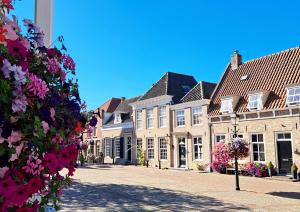 a street in a town with houses and flowers at De Zandparel in Poortvliet