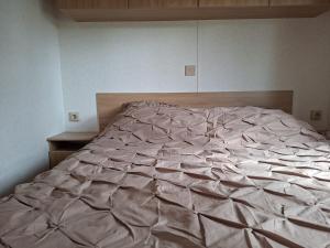 an unmade bed in a bedroom with at De Zandparel in Poortvliet