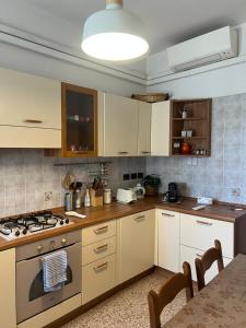 a kitchen with white cabinets and a stove top oven at Nebula Nook Luxury Apartment in Modena
