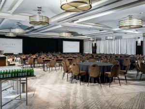 a large room with tables and chairs and a screen at Sofitel Philadelphia at Rittenhouse Square in Philadelphia