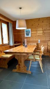 a dining room with a wooden table and chairs at Alpenchalet Trutmundi undri in Eischoll