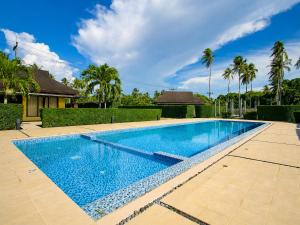 a swimming pool in a yard with palm trees at Chaba Villa at Had Yao Beach in Had Yao Beach
