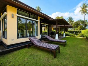 a house with two lounge chairs in the yard at Chaba Villa at Had Yao Beach in Had Yao Beach