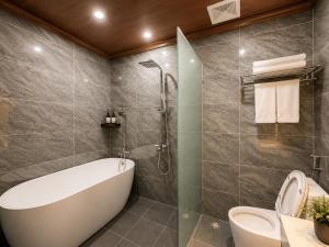 a bathroom with a bath tub and a toilet at Luang Prabang Indochine Heritage Hotel in Luang Prabang