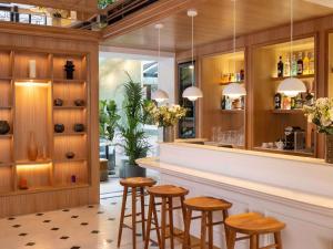 a bar in a restaurant with stools at Hotel Mercure La Sorbonne Saint-Germain-des-Prés in Paris +45 photos