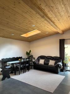 a living room with black furniture and a wooden ceiling at Vacation with Purpose in Gura Humorului