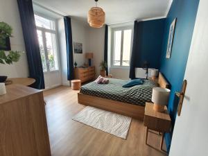 a bedroom with a bed and blue walls at Logis cosy du centre ville in Aix-les-Bains +4 photos