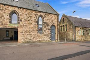 an old brick church with a blue door and windows at 5 Old Templars - North East Escapes in Spittal