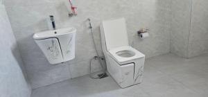 a bathroom with a white toilet and a sink at Cornerstone Hotel Arusha in Arusha