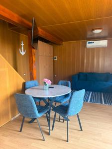 a dining room with a table and blue chairs at VILLAGEbythelake Bicaz in Bicaz