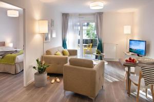 a living room with a bed and a couch and a table at Domitys - Galilée in Cergy