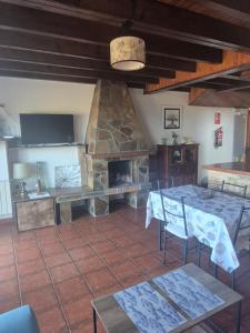 a living room with a table and a stone fireplace at La Morada del CABO PEÑAS Folu - Gozón - Luanco in Ferrero