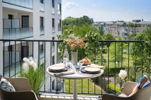 a table with plates of food on a balcony at Domitys - Galilée in Cergy