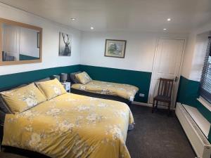 a hotel room with two beds and a window at The Pickwick Inn in Kingsbridge