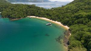 an aerial view of a beach with boats in the water at Paraíso Azul Retiro in Abraão +144 photos