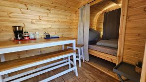 a wooden cabin with a counter and a bench in it at Camping Schlaffass Naima in Burg +6 photos